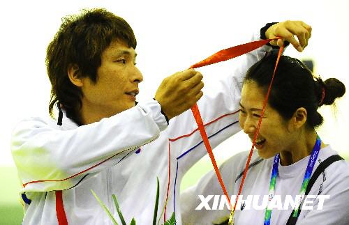 9月11日,韩国选手李知锡为妻子朴金顺挂上金牌。 当日,韩国选手李知锡在北京2008年残奥会R4级混合组10米气步枪立射-SH2决赛中以704.3环的总成绩获得冠军,这是他在本届残奥会上获得的第二枚射击金牌。他在赛后接受采访时说:“我的妻子对我帮助很大,是我射击时最重要的助手。我要向她表示最衷心的感谢!” 2001年,27岁的李知锡遭遇交通事故,不得不与轮椅为伴。就在很多人认为他将从此一蹶不振时,李知锡认识了现在的妻子,当时在康复医院照顾他的美丽护士朴金顺。在朴金顺的支持和悉心照顾下,李知锡从2003年开始从事射击运动。 9月9日,首次参加残奥会的李知锡获得R5级混合组10米气步枪卧射-SH2比赛冠军。两天后,他再夺一金。在比赛中,已经怀孕6个月的朴金顺一直陪伴在李知锡身后,亲手为他装入每发子弹,爱情的伟大力量让他弹无虚发,最终两次登上最高领奖台。 新华社记者任勇摄