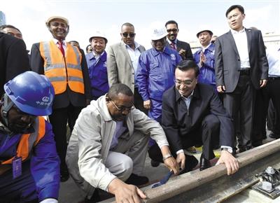 当地时间5月5日,李克强总理考察亚的斯亚贝巴轻轨项目,埃塞俄比亚总理海尔马里亚姆陪同。看到中埃双方员工正在铺轨作业,李克强同海尔马里亚姆一起拿起扳手,拧紧螺丝。新华社发