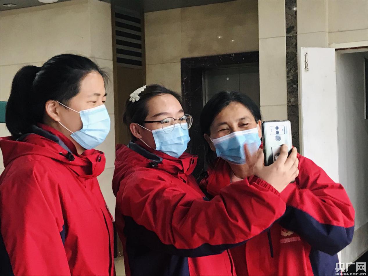 医疗队员正和患者视频聊天 右一为袁莉萍(央广网发 赵家慧摄)