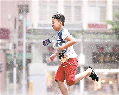 昨日,广州突如其来下了一场大雨,一个小男孩在雨中奔跑.