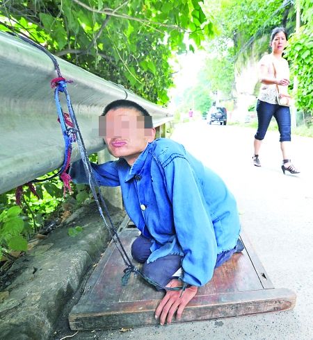 江津白沙镇,被捆在公路边的何贵明。 首席记者 钟志兵 摄