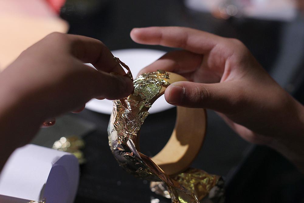 美术馆除了展览漆器外,还能成为孩子们体验传统工艺的课堂。 想一想,手镯除了戴,还能做什么?可以做相框。可以放杯子。5月3日,徐汇艺术馆里笑声一片,来自光启小学等学校的五年级孩子在漆器艺术家项军的带领下制作漆器手镯,孩子们天马行空的想象力令在场老师惊讶不已。徐汇艺术馆联手徐汇区教育学院课程教学研修中心,同时邀请木川涧漆艺空间共同合作,结合大漆司器源于生活的漆器艺术展推出漆艺主题的美术馆里上美术课活动,学校、美术馆、艺术家三方的协作和碰撞,让学生在美术馆展览氛围中认识漆器在中国