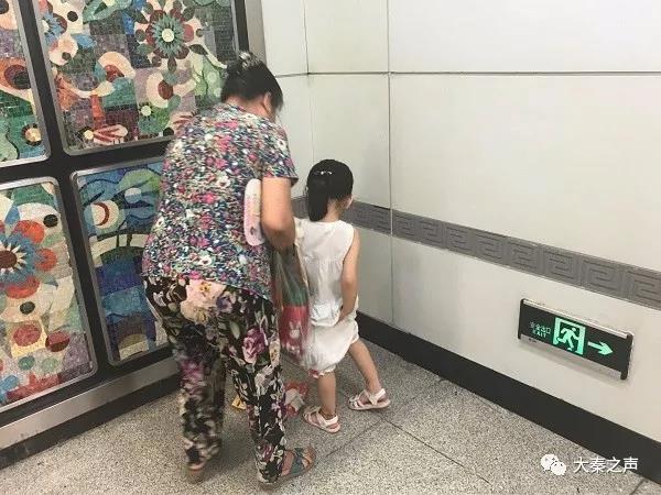 纳凉市民带小孩在地铁站小便
