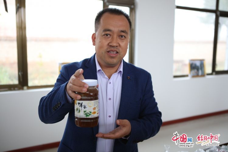 张喜东向记者推荐他们独具特色的荞麦花蜂蜜.贺冬鹏/摄