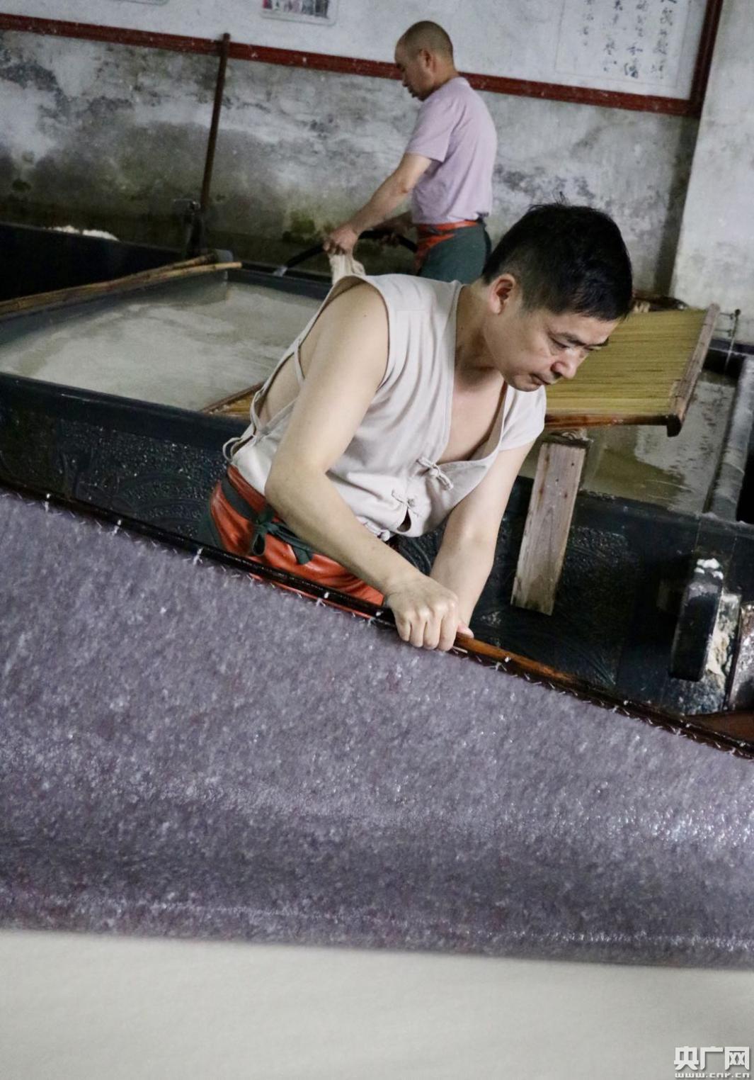 工人们正在进行捞纸作业.(央广网发赵家慧摄)