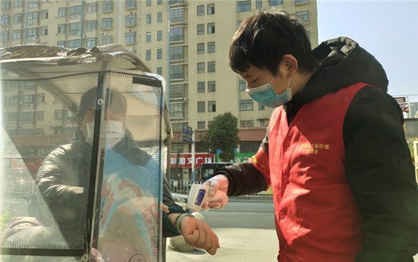 杨传喜给进入小区居民测体温