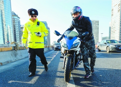 在东三环国贸桥上,交警拦下一辆在主路行驶的摩托车