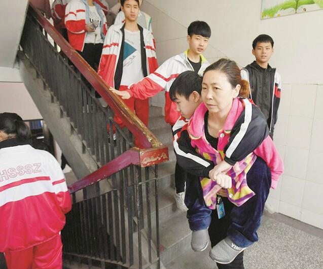 两儿子均患肌营养不良女子十余年背儿上学