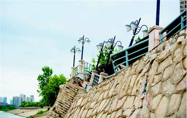 图为:观景台的堤岸出现倾斜和裂缝,上面的景观灯和栏杆都歪了