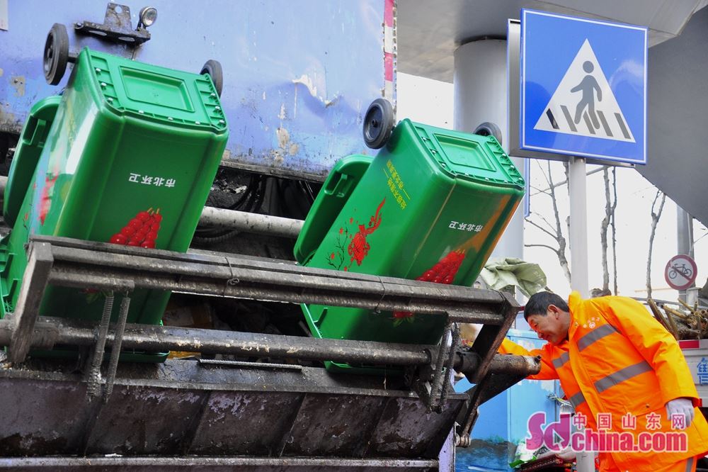 吕师傅正在操作压缩垃圾车,将会场内垃圾桶的垃圾倒入车中.