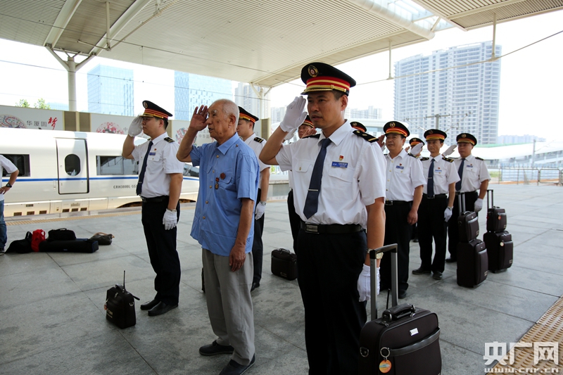 阎世恩老人,薛军以及其他工作人员面向"复兴号"列车敬礼
