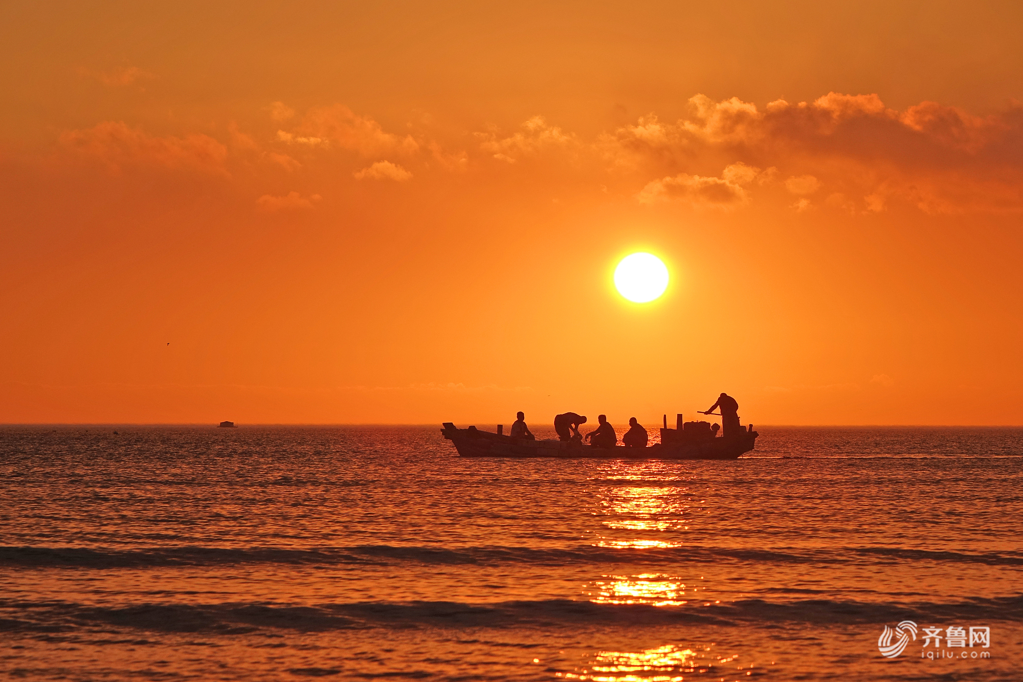 山东烟台海滨,渔民伴着朝阳在海上劳作.