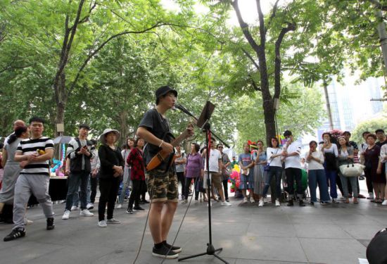 静安公园门口,街头艺人的吉他弹唱吸引不少游客.