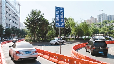 由长安路驶入二环辅道,主道的车辆,通过红色的水马分隔驶入不同位置