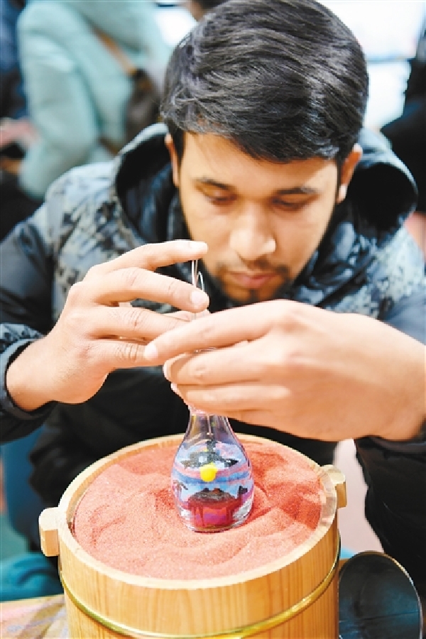 山凯·汗很喜欢西安文化和古建筑,他创作了大雁塔标志性建筑的沙画瓶