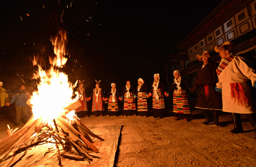 11月12日,内地游客和藏族群众一起围着篝火跳锅庄.
